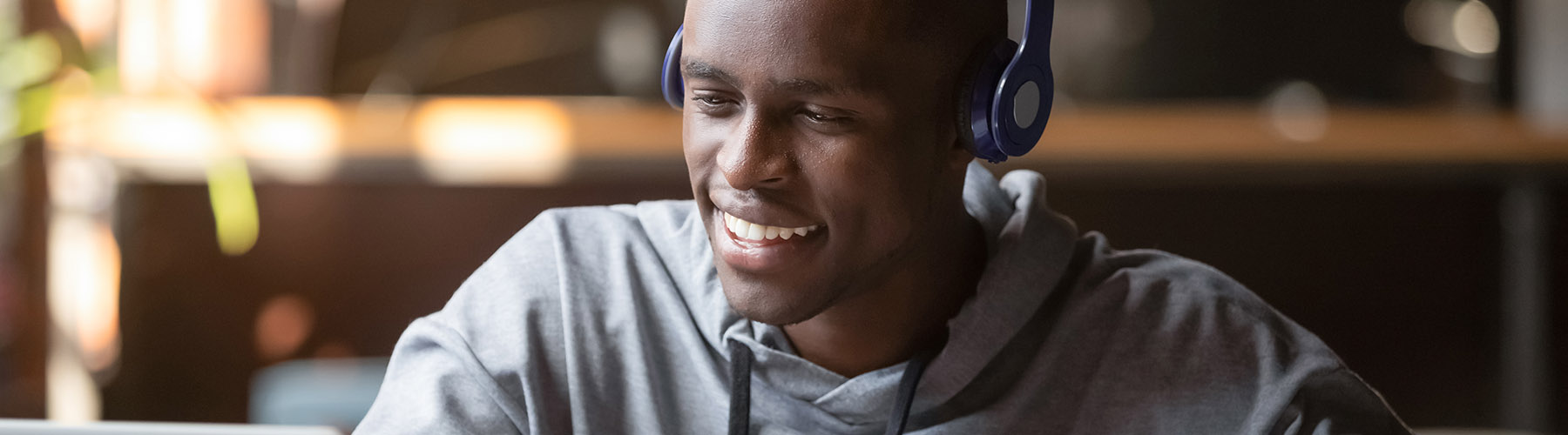 Smiling african young man student wearing headphones study online